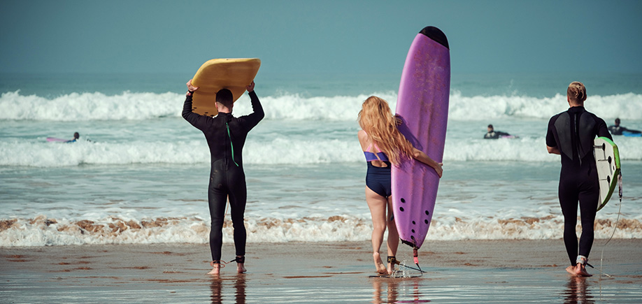 People walking with Surfboards